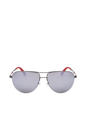 Occhiali da sole con montatura aviator argentata, lenti riflettenti grigie e terminali rossi delle stanghette, mostrati frontalmente su sfondo bianco.