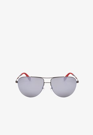 Occhiali da sole con montatura aviator argentata, lenti riflettenti grigie e terminali rossi delle stanghette, mostrati frontalmente su sfondo bianco.