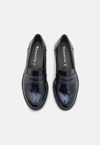 Paire de mocassins en cuir verni noir brillant avec bouts arrondis et semelles intérieures de marque, vus de dessus sur fond blanc.
