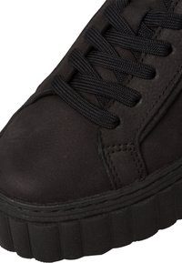 Czarny skórzany sneaker z teksturowaną cholewką, płaskimi czarnymi sznurowadłami oraz grubą, ryflowaną gumową podeszwą. Minimalistyczny design z gładkim wykończeniem.