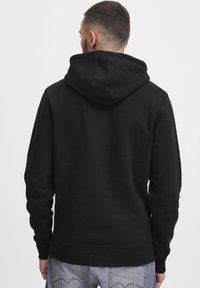 Black hooded sweatshirt with a relaxed fit, ribbed cuffs, and hem. Features a kangaroo pocket and soft, textured fabric.