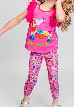 Lyserød kortærmet skjorte med flæsedetaljer og et farverigt dyreprint, kombineret med pink leggings med blomsterprint.