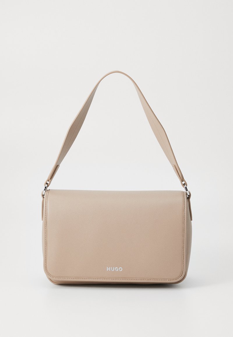 Bolsa de couro bege com uma textura suave, forma retangular, alça ajustável e ferragens prateadas, apresentando um logótipo discreto na frente.