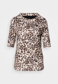 Blouse beige avec imprimé léopard noir et marron, manches courtes et col rond large.
