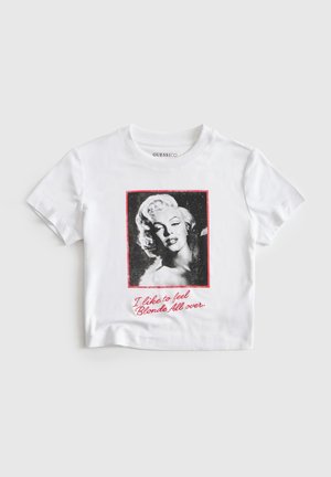 Witte T-shirt met korte mouwen met een zwart-wit portret van een blonde vrouw en rode tekst met de tekst "Ik hou ervan om me overal blond te voelen."