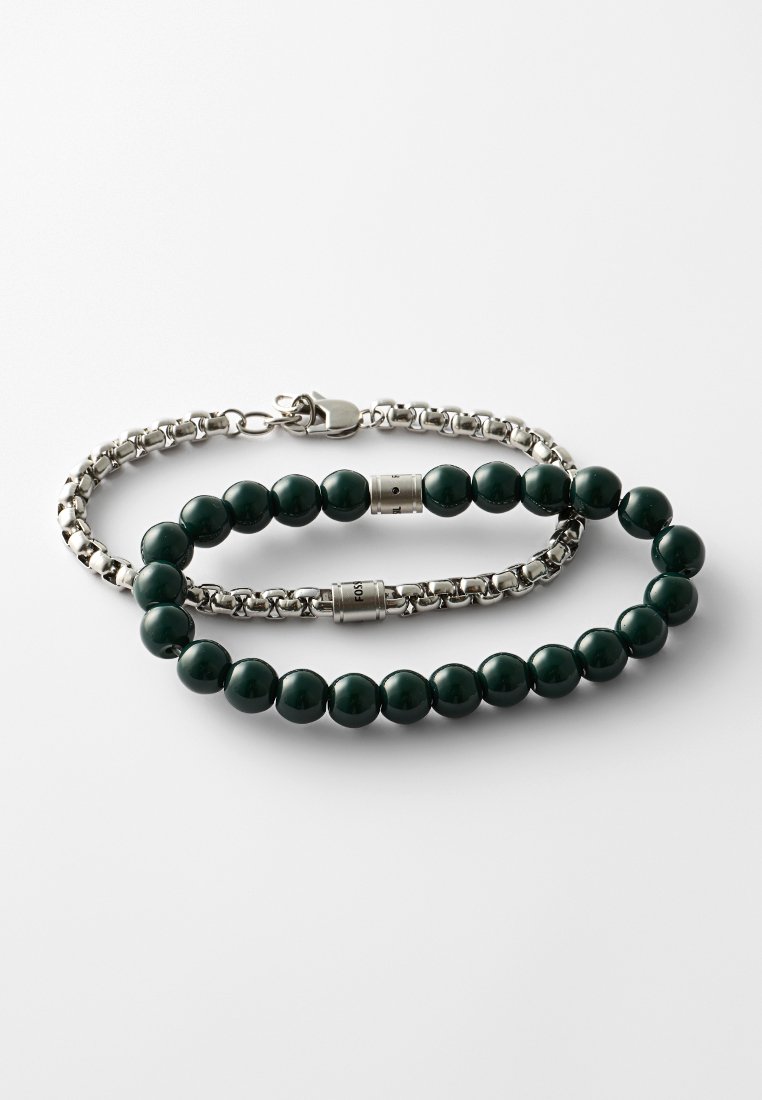 Deux bracelets : l'un avec des perles vernies vert foncé et des accents en métal ; l'autre est une chaîne en argent avec un fermoir.