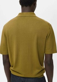 Kortärmad polo skjorta i senapsgul, stickad tyg, med klassisk krage och ribbade ärmslut, har en ren, minimalistisk design.