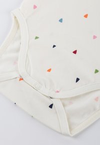 Weißer Baumwollbody mit bunten dreieckigen Mustern in Rosa, Blau, Grün, Orange und Marineblau; mit Druckknöpfen am Boden.