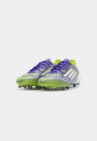 Purple and green soccer cleats with a sleek design, textured upper, and clear outsole featuring multiple studs for traction.