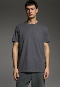 Czarny szary bawełniany t-shirt z krótkim rękawem, okrągłym dekoltem, prostym kroju, z minimalnym logo na klatce piersiowej.