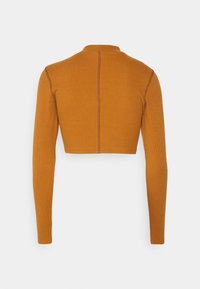 Långärmad kort topp i senapsgul ribbad tyg. Har en hög halsringning och kontrastsömnad längs bakseam.