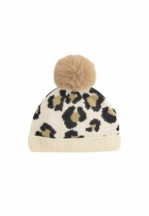 Knit beanie with a cream base, featuring black and tan leopard spots, and a fluffy tan pom-pom on top. Ribbed texture at the bottom.