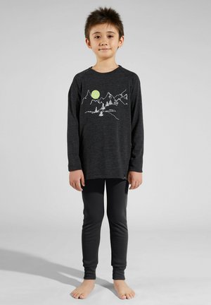 Black long-sleeve shirt with white mountain graphic and green sun, paired with black fitted leggings, worn barefoot. Smooth, lightweight fabric.