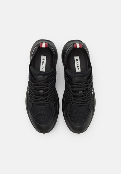 Scarpe da atletica nere con una tomaia tessuta texturizzata, dettagli in pelle liscia e linguette sul tallone in rosso e bianco a contrasto. Presentano lacci e marchio.