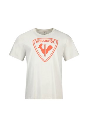 Camiseta blanca de manga corta con el logo naranja de Rossignol que presenta un gallo estilizado dentro de un escudo en el pecho.
