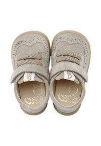 Zapatos de ante beige con un diseño perforado en forma de corazón, cordones elásticos y correa de velcro. Suelas de goma para tracción y durabilidad.