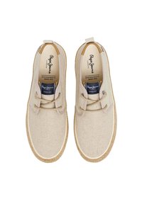 Scarpe di tela beige con finitura testurizzata, punta rotonda, design con lacci e suola in corda naturale. Presenta un logo sulla linguetta.