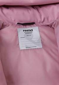 Różowa wodoodporna kurtka od wewnątrz z etykietą z informacjami o pielęgnacji materiału, na której widnieje marka "reima" oraz informacje o rozmiarze "128 / 8Y". Gładka tekstura.