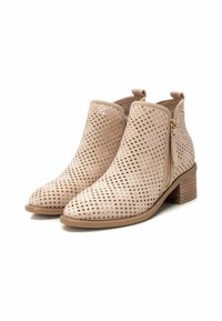 Botas de tobillo beige perforadas con un modesto tacón cuadrado, cremallera lateral y acabado de ante texturizado, con un diseño de punta afilada.