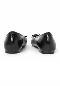 Bailarinas negras hechas de material sintético brillante con una textura suave, punta redondeada y lazos decorativos en la parte frontal.