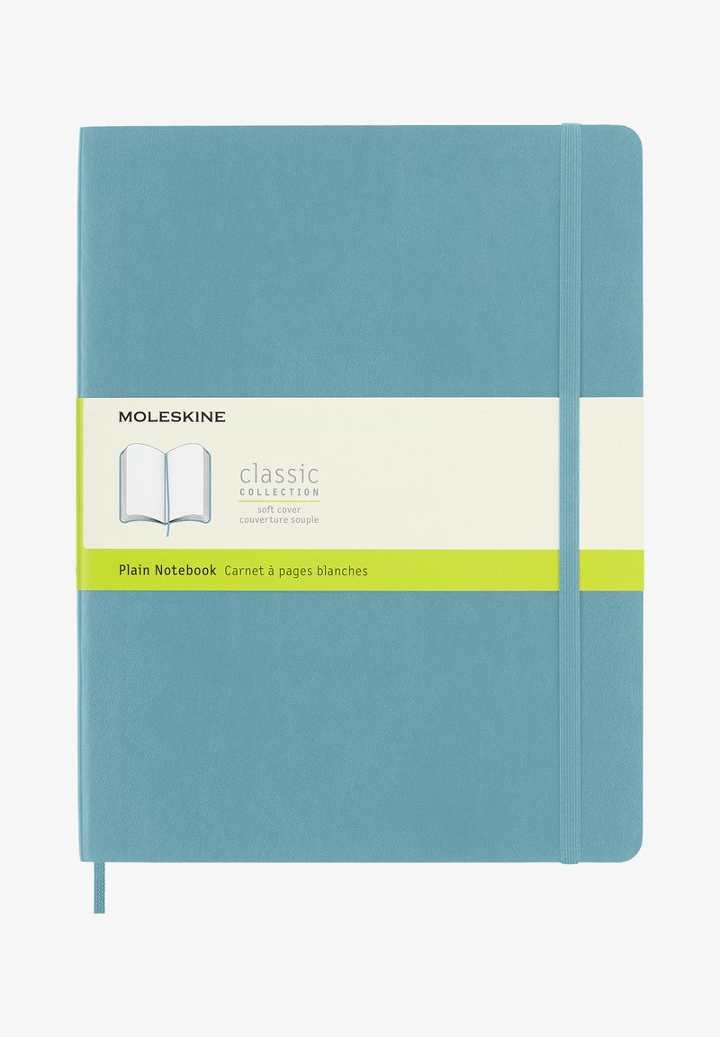 Taccuino Moleskine con copertina morbida, caratterizzato da una copertura color teals, chiusura con elastico e un'etichetta gialla con i dettagli del prodotto.