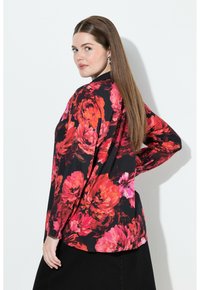 Langærmet bluse med sort baggrund og store, livlige røde og pink blomsterprint. Glat stof med en let løs pasform.