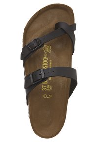 Sandalias de piel negra con dos correas ajustables, plantilla de corcho marrón y detalles impresos en amarillo con el tamaño y la marca en la plantilla.
