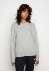 Sweatshirt gris en tissu mélangé coton, avec un col rond, des poignets côtelés et un petit logo Nike blanc sur la poitrine.