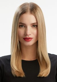 Figurine féminine avec de longs cheveux blonds clairs et lisses, portant un shirt noir. Présente des lèvres rouges vives et des yeux verts sur un fond blanc.