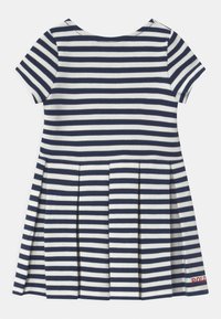 Niebiesko-biała sukienka w paski z krótkim rękawem, z plisowanym dołem i czerwoną haftowaną literą "POLO" na dolnej krawędzi. Materiał mieszanka bawełny. Klasyczny okrągły dekolt.