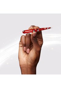 Hånd med negle i manicure holder røde Tweezerman-pincetter dekoreret med Mickey- og Minnie Mouse-mønstre mod en lys baggrund.