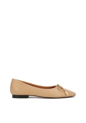 Béžová balerína so špicatou špičkou, malou mašličkou a zlatým štítkom na nízkom čiernom podpätku.