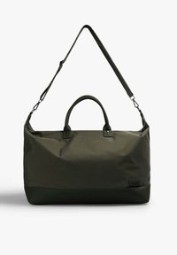 Bolsa de deporte de color verde oscuro, hecha de nylon, que cuenta con dos asas superiores y una correa de hombro ajustable con clips de metal. Textura suave y diseño sencillo.