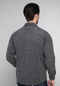 Grijze herringbone-patroonjack met een kraag, lange mouwen en knoopmanchetten; gemaakt van textuurstof; rechte zoom aan de achterkant.