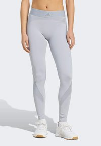 Lichtgrijze leggings met een hoge taille en een slank ontwerp. Voorzien van contrasterende meshpanelen en subtiele branding op de tailleband.