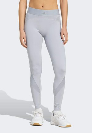 Leggings gris clair avec taille haute et design élégant. Présente des panneaux en maille contrastants et un branding subtil sur la ceinture.