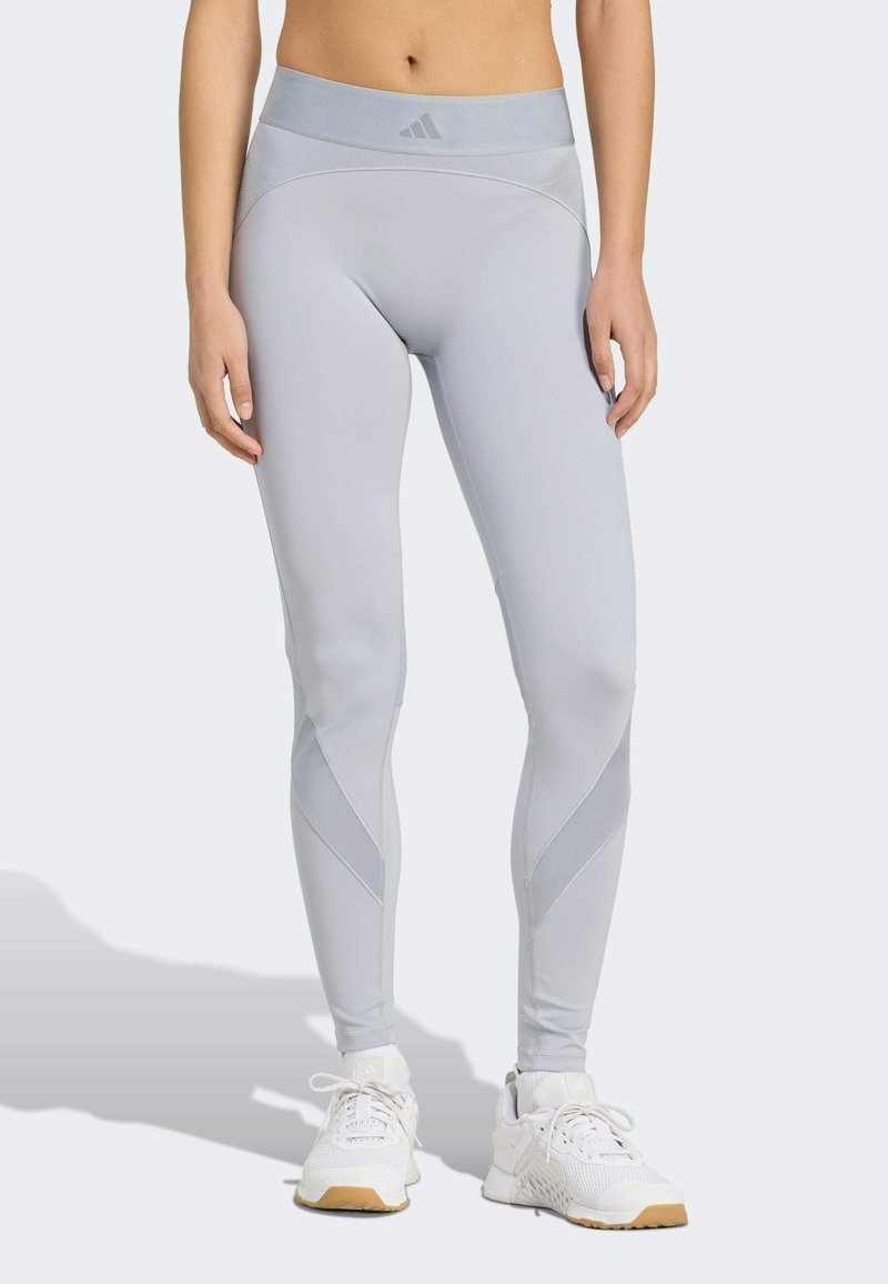 Lichtgrijze leggings met een hoge taille en een slank ontwerp. Voorzien van contrasterende meshpanelen en subtiele branding op de tailleband.