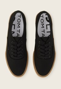 Sneakers neri di tela con punta tonda, lacci neri e suola in gomma. Presentano una soletta con marchio e un design semplice senza decorazioni.