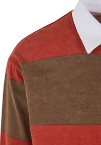 Rød og brun stripete polo skjorte med hvit krage. Stoffet ser mykt ut med en jevn tekstur og jevn fargefordeling.