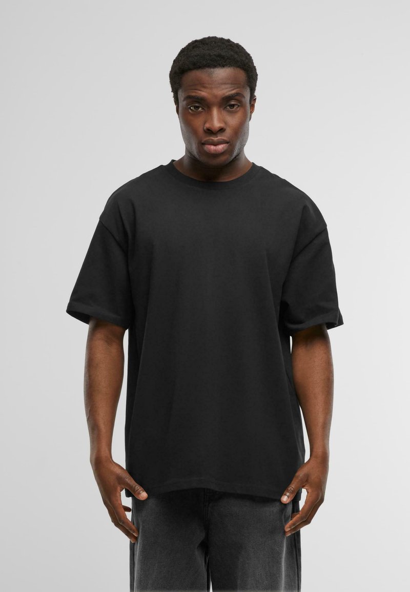 Zwarte oversized t-shirt van katoen, met een ronde hals en korte mouwen, gepresenteerd met een effen, gladde textuur.