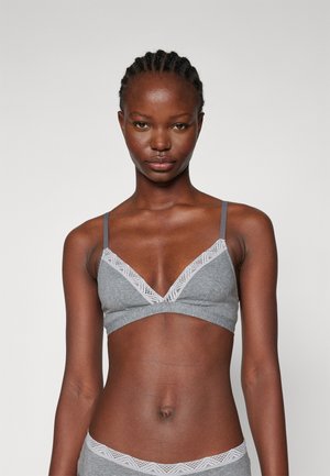 Grijze bralette met verstelbare banden, een V-hals en een kantafwerking langs de rand. Zacht materiaal en een naadloos ontwerp zorgen voor comfort.