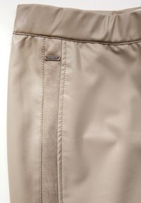 Beige leren rok met een suede streep, voorzien van een discrete metalen logo-label en gestikte details langs de naden. Over het algemeen een gladde textuur.