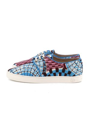 Paire de baskets basses avec des motifs géométriques et à carreaux bleus, roses et noirs, semelles blanches et lacets blancs sur fond blanc.