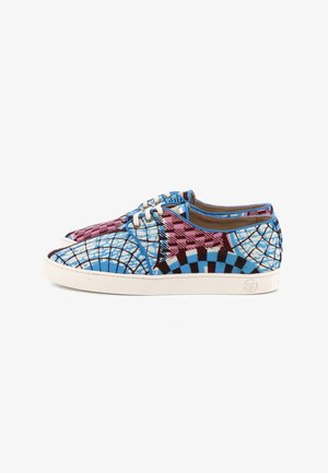Paire de baskets basses avec des motifs géométriques et à carreaux bleus, roses et noirs, semelles blanches et lacets blancs sur fond blanc.