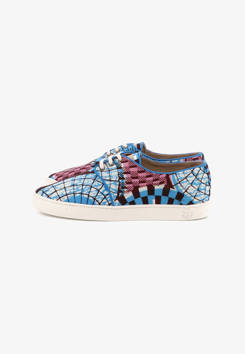 Paire de baskets basses avec des motifs géométriques et à carreaux bleus, roses et noirs, semelles blanches et lacets blancs sur fond blanc.