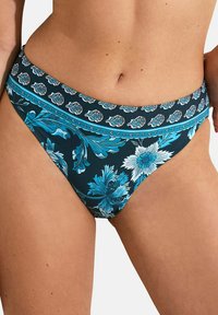 Bas de bikini floral présentant une base bleu marine, des motifs floraux turquoise et blancs complexes, et une ceinture décorative.