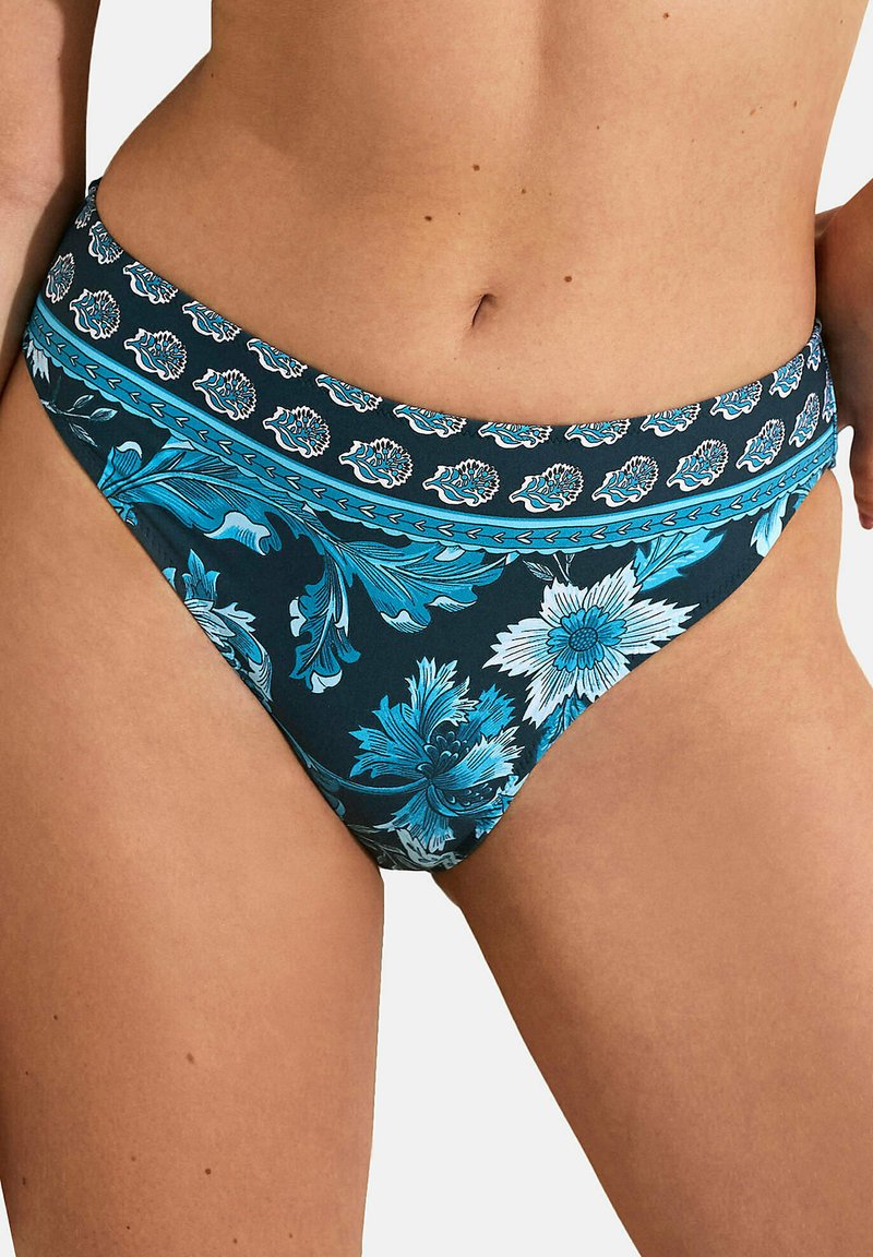 Bas de bikini floral présentant une base bleu marine, des motifs floraux turquoise et blancs complexes, et une ceinture décorative.