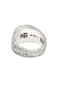 Ezüst gyűrű érdes, matt felületű. Simára polírozott belső felülete van, a 925-ös ezüst minőségét jelző gravírozott mintákkal.