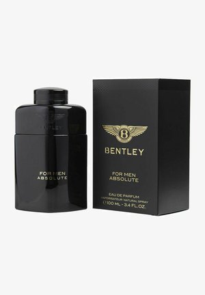 Sort glasflaske med en afrundet top, præget logo og gyldent tekst. Begge dele ledsaget af en matchende sort æske med guld accenter.