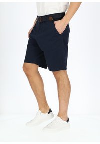 Navy blue shorts made of cotton, featuring side pockets and a woven black belt with a brown accent, paired with white sneakers.